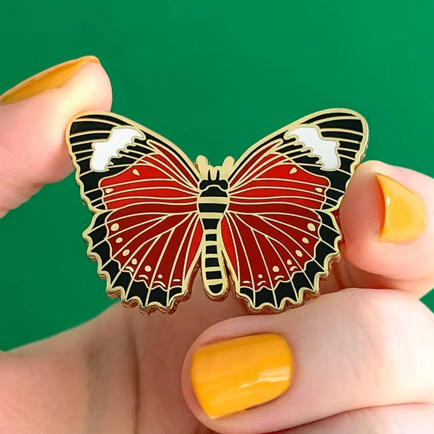 Wings Laced In Red Enamel Pin